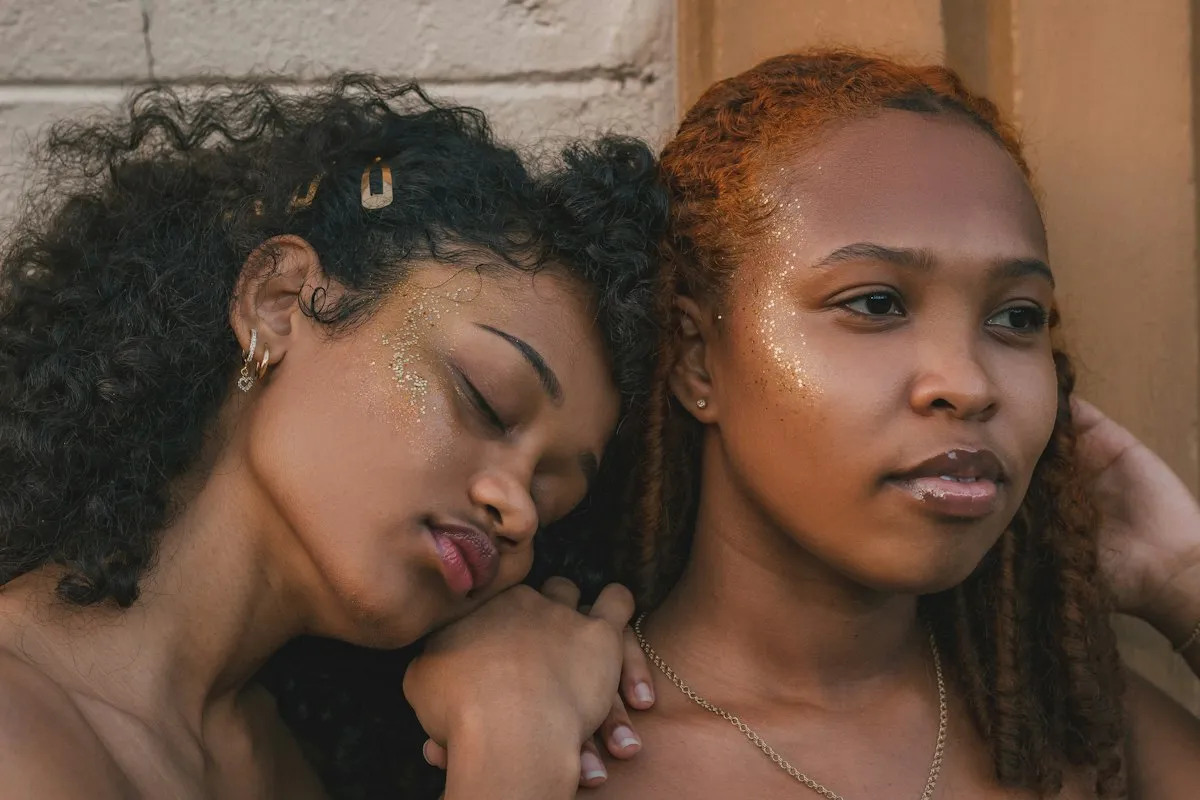 Dos mujeres abrazadas con los ojos cerrados, serenas