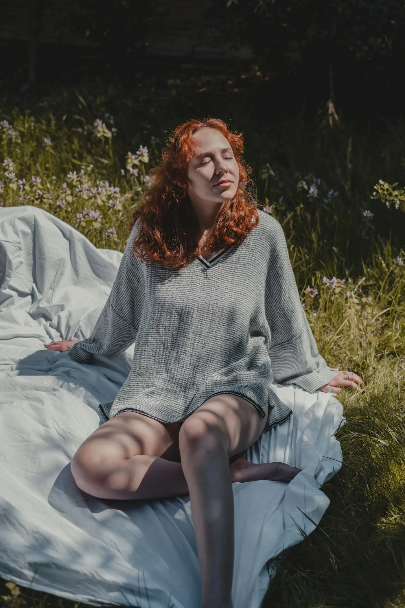Mujer descansando sobre una manta en el campo, con los ojos cerrados