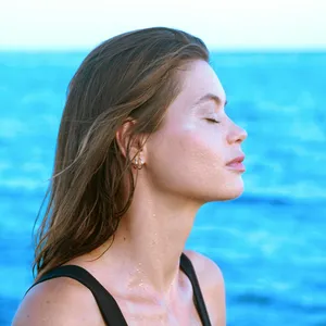 Mujer con los ojos cerrados frente al mar